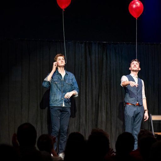 Zauberkünstler Felix Wührer, links zu sehen und Maxi Muschaweck, rechts zu sehen, welche in ihrer Show "ZauberKunst erleben" rote Ballons steigen lassen